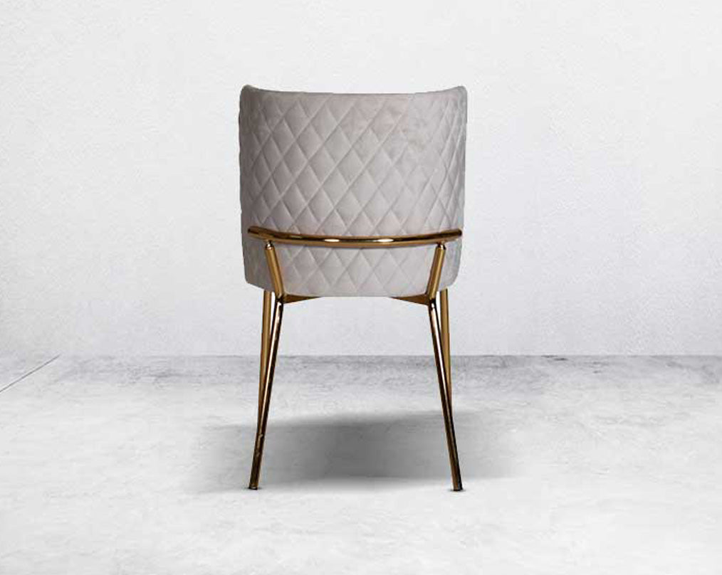 Minimalistically designed chair back with criss-cross stitch padded fabric in gold finish stainless steel legs in contemporary design.