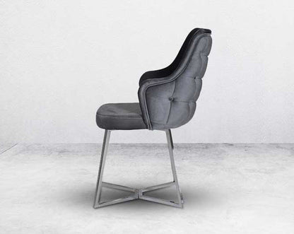 This soft, cushioned dining chair features an extraordinary contemporary design with a tufted back and cushioned seat with stainless steel legs.