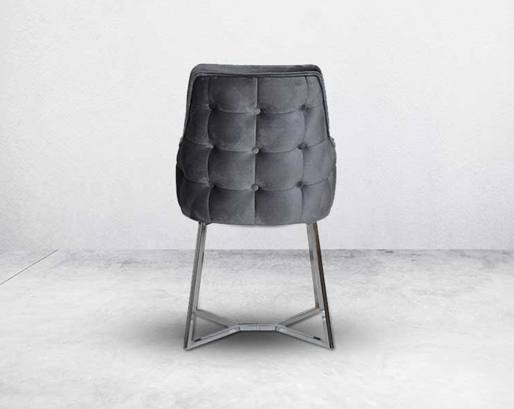 This soft, cushioned dining chair features an extraordinary contemporary design with a tufted back and cushioned seat with stainless steel legs back view