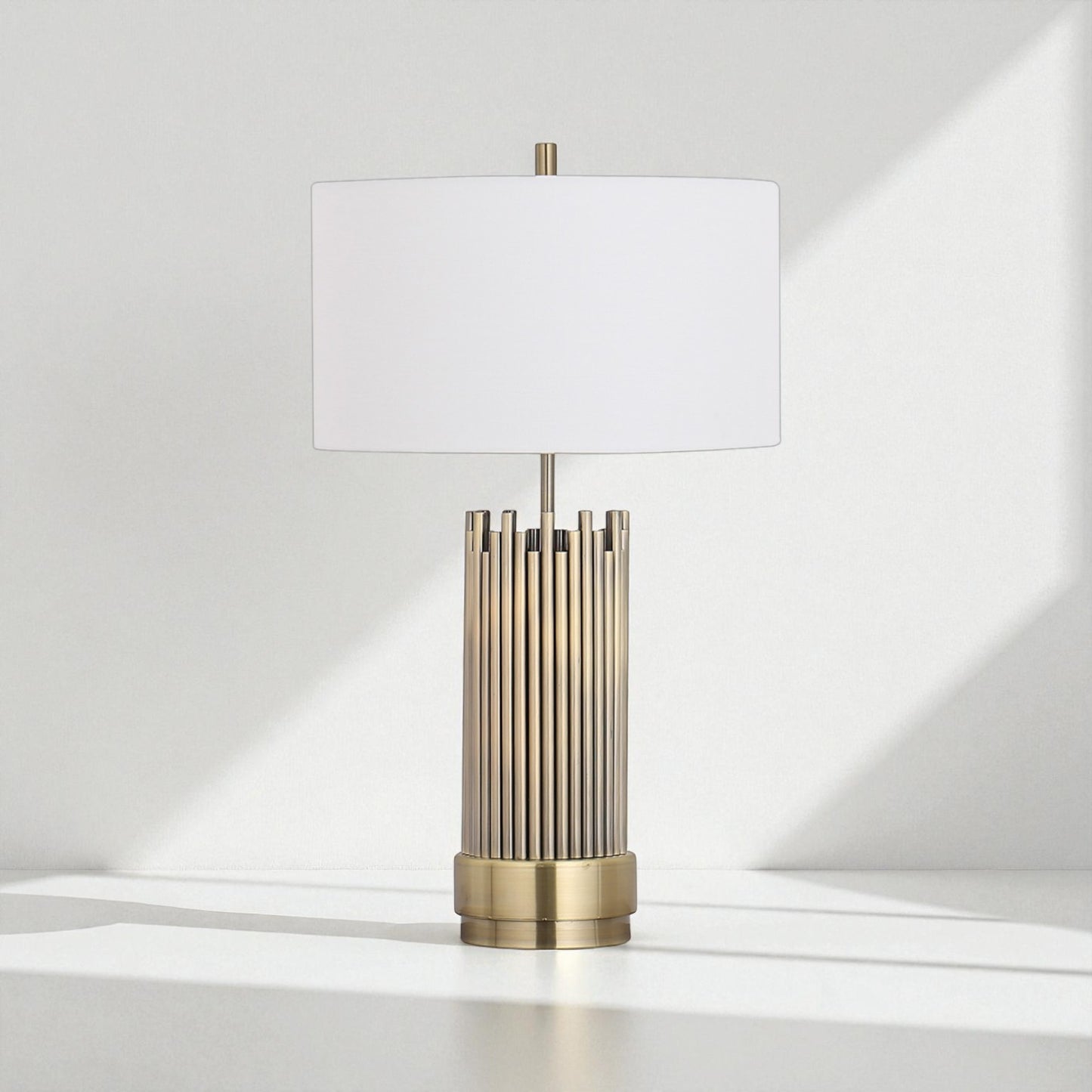Table lamp with brass base and white shade on a light gray background