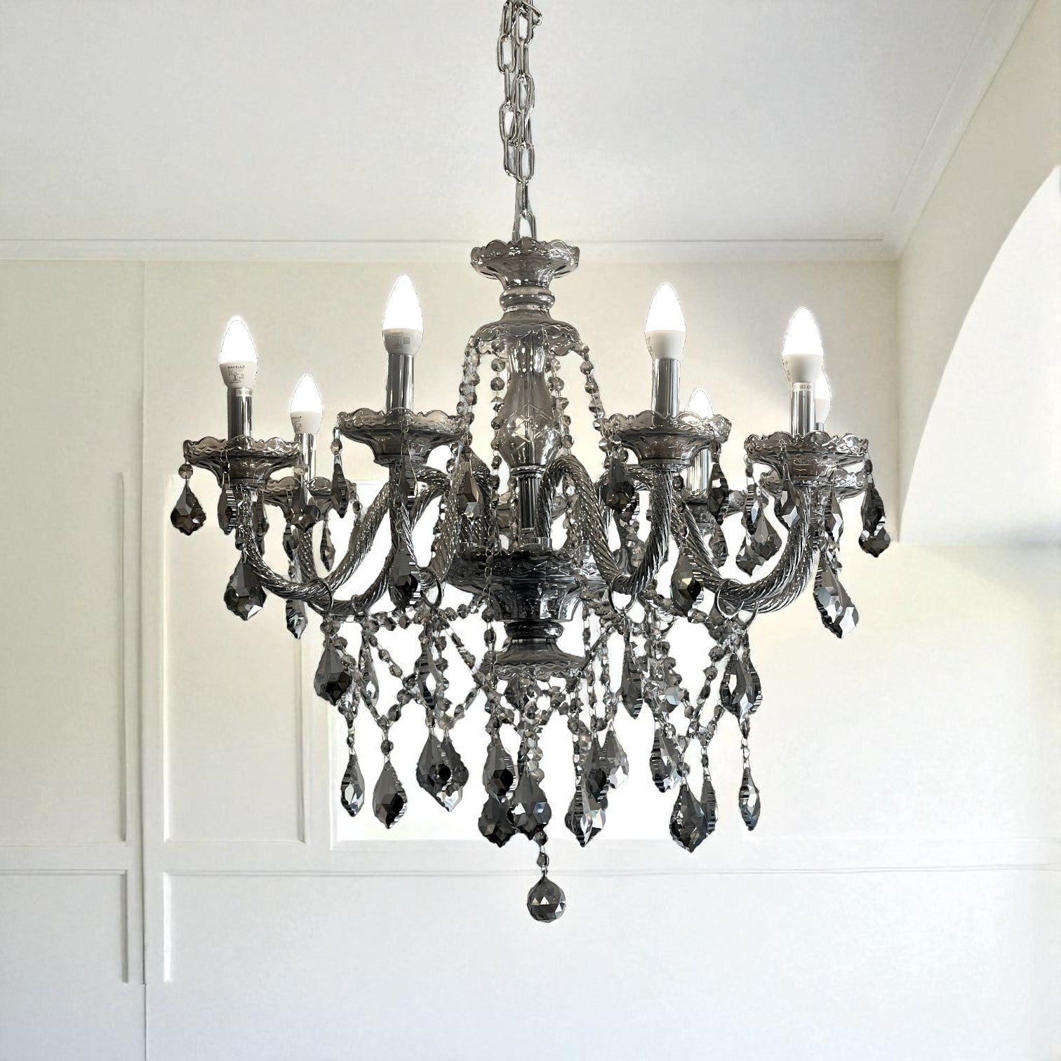 Decorative chandelier hanging in a room with white walls and ceiling.