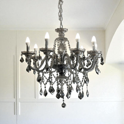 Decorative chandelier hanging in a room with white walls and ceiling.