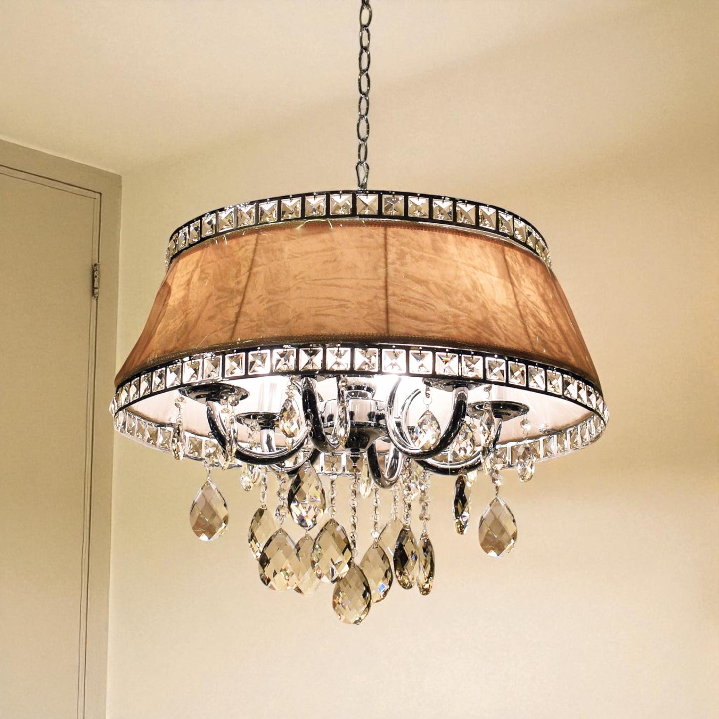 Chandelier with crystal accents and a brown shade on a beige wall.