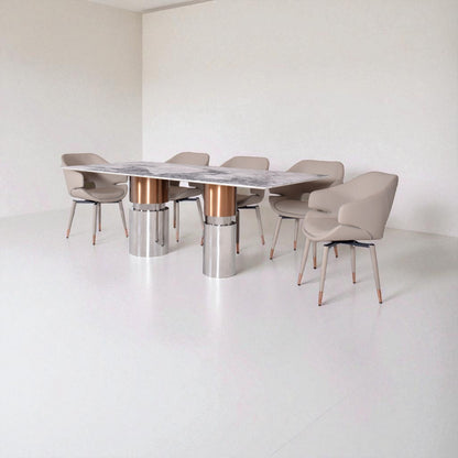 Modern dining table with marble top and metallic base, surrounded by beige chairs in a minimalistic setting.