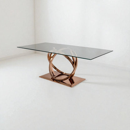 Modern glass dining table with rose gold metal base on a white background