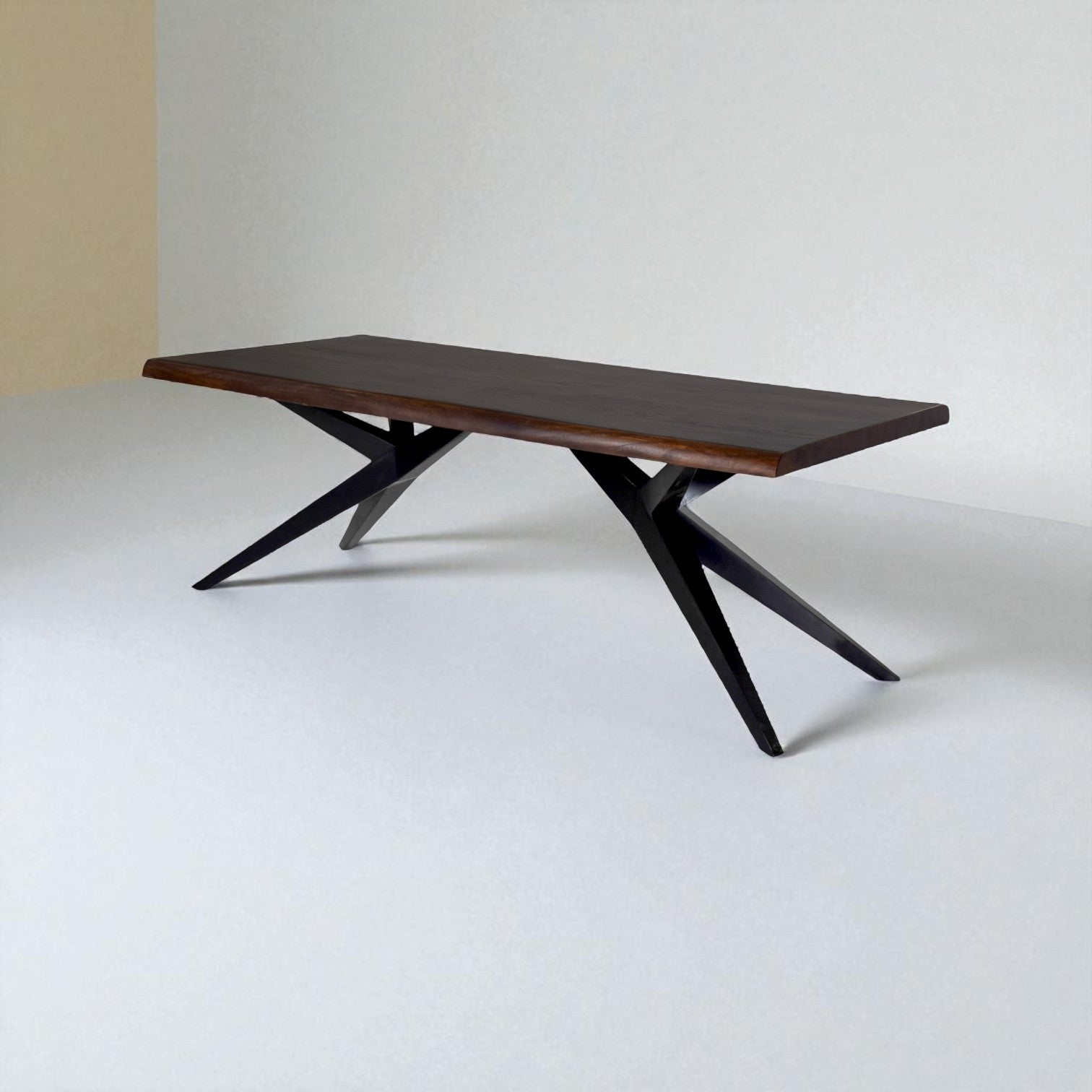 Wooden dining table with black metal legs on a white background