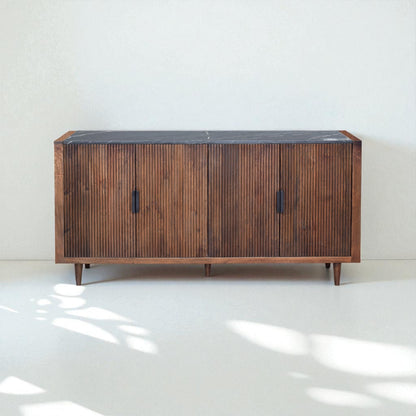 Wooden sideboard with a black top on a white floor and light gray wall
