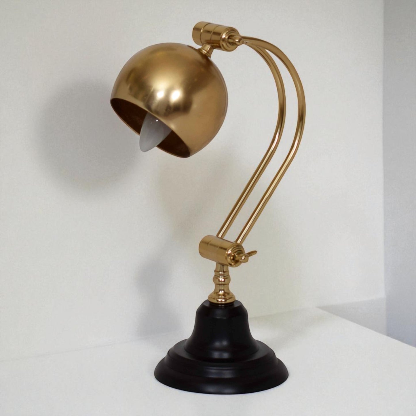 Gold and black desk lamp on a white background