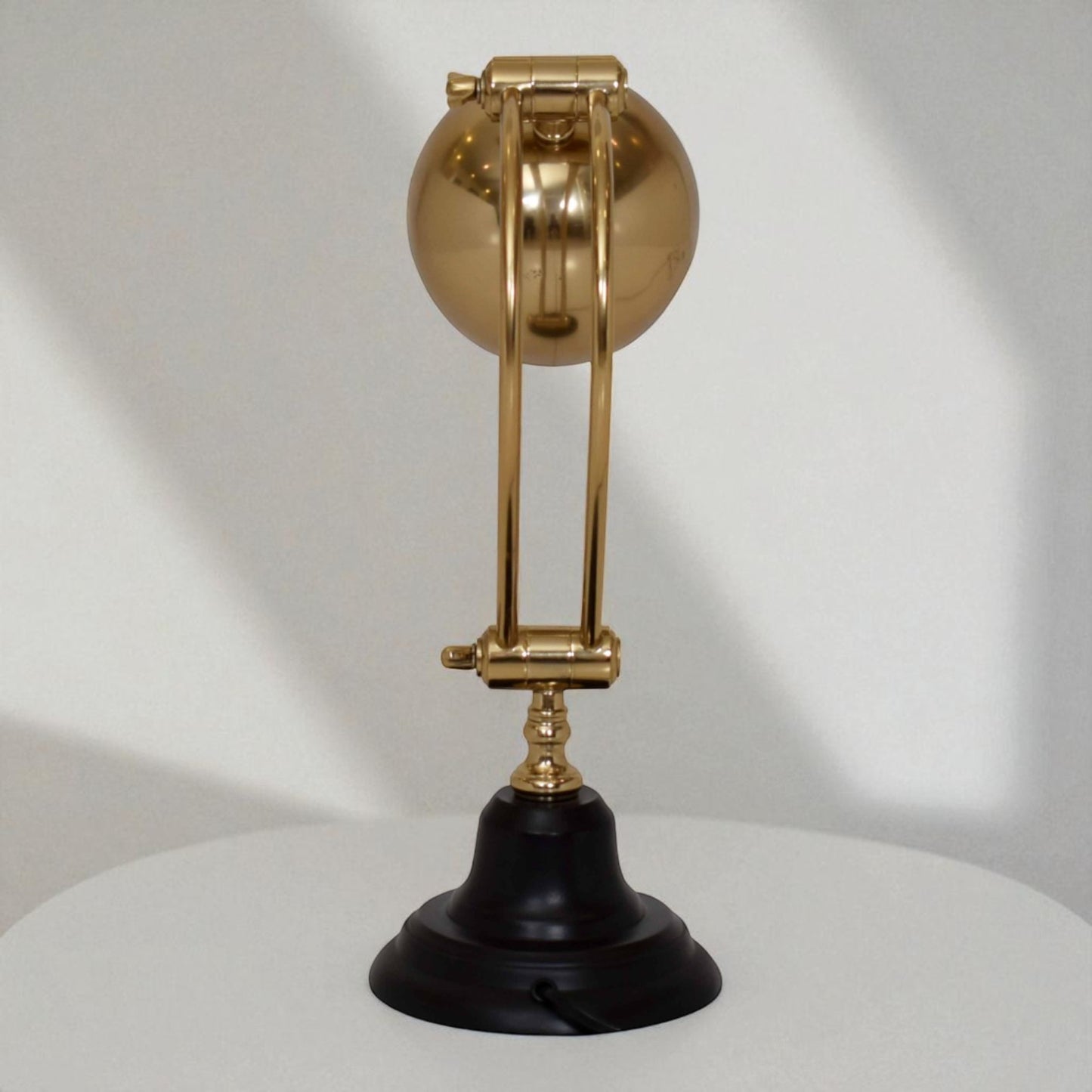 Decorative lamp with gold spherical top and black base on a white background
