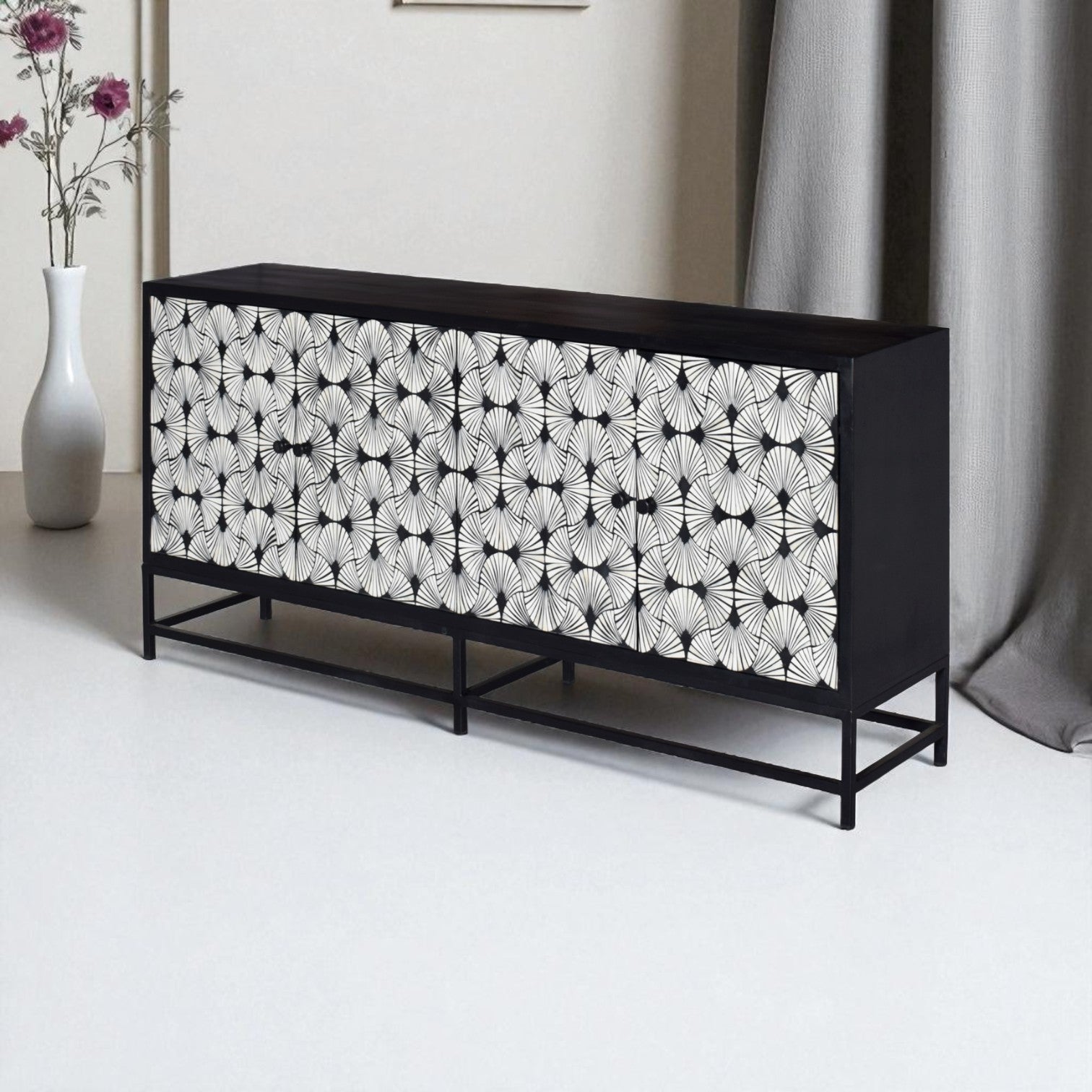 Black and white patterned sideboard in a room with a vase and curtain.