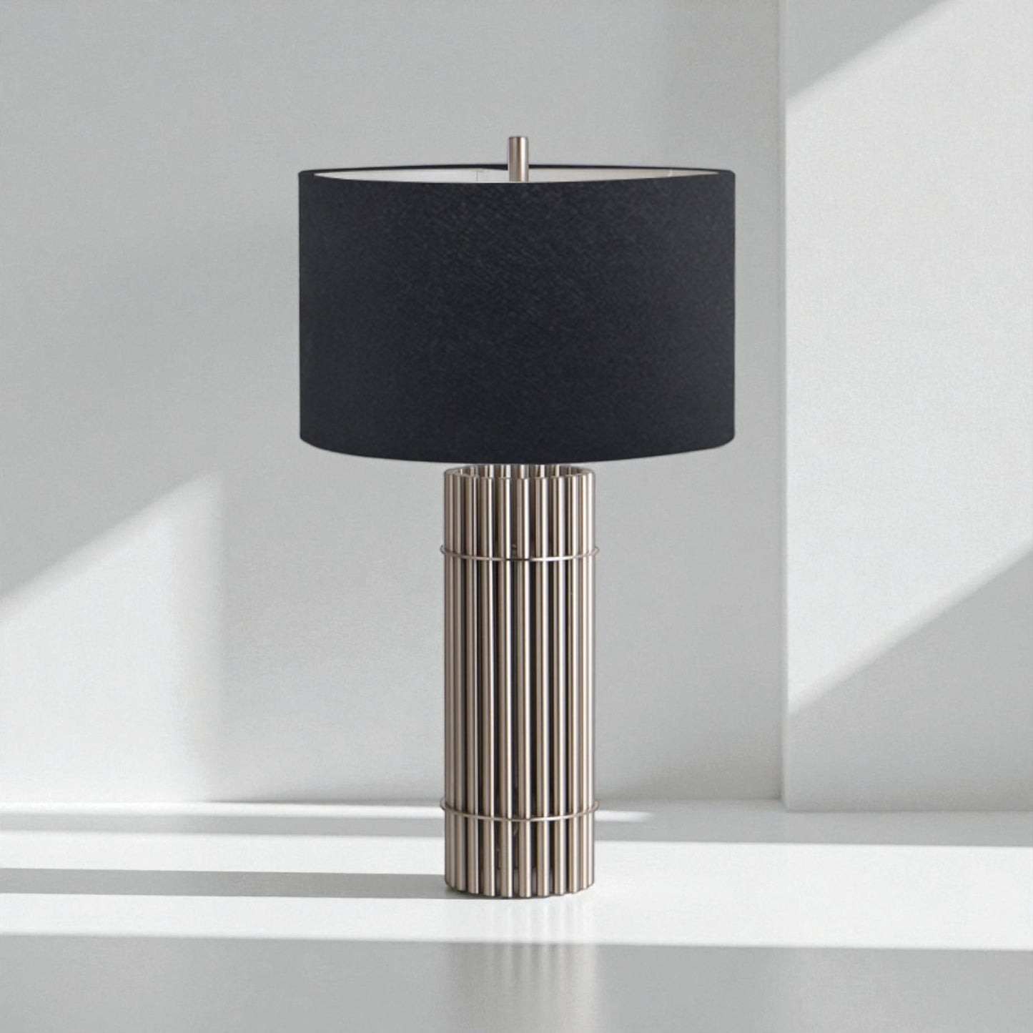 Table lamp with black shade and metallic base on a white surface.