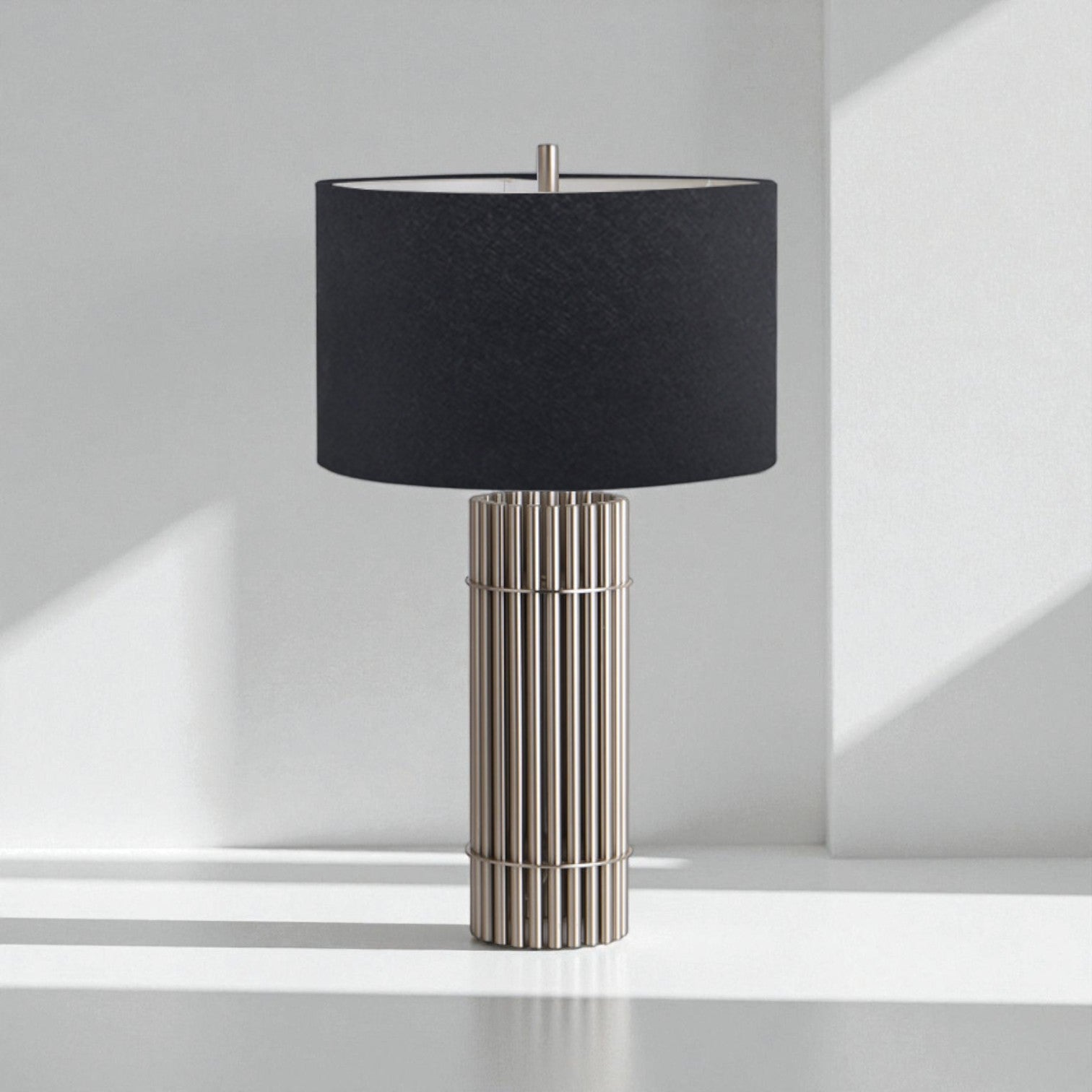 Table lamp with black shade and metallic base on a white surface.