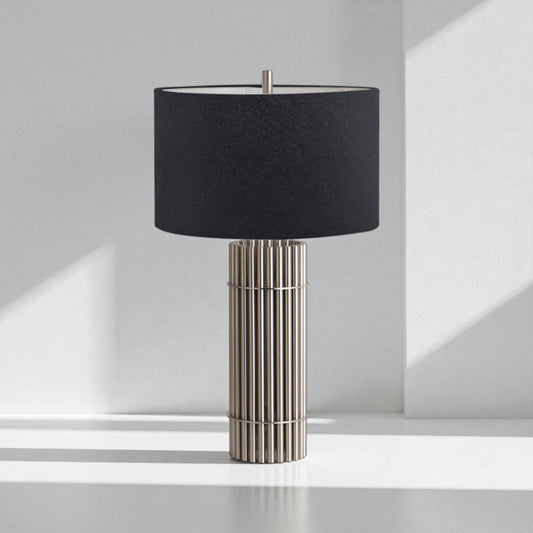 Table lamp with black shade and metallic base on a white surface.