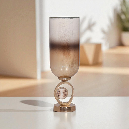 Decorative glass vase with a metallic base on a white surface