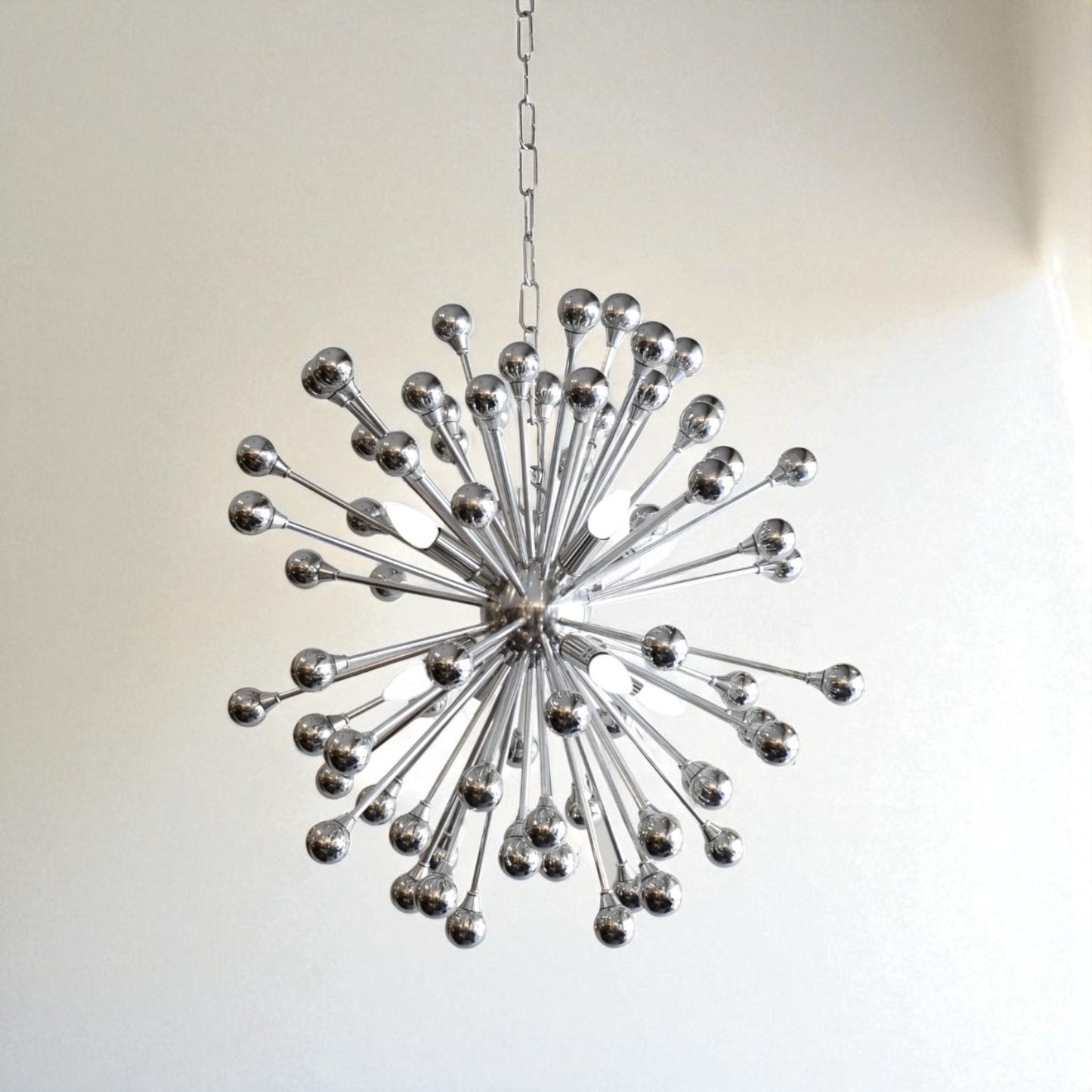 Decorative chandelier with a starburst design on a plain background