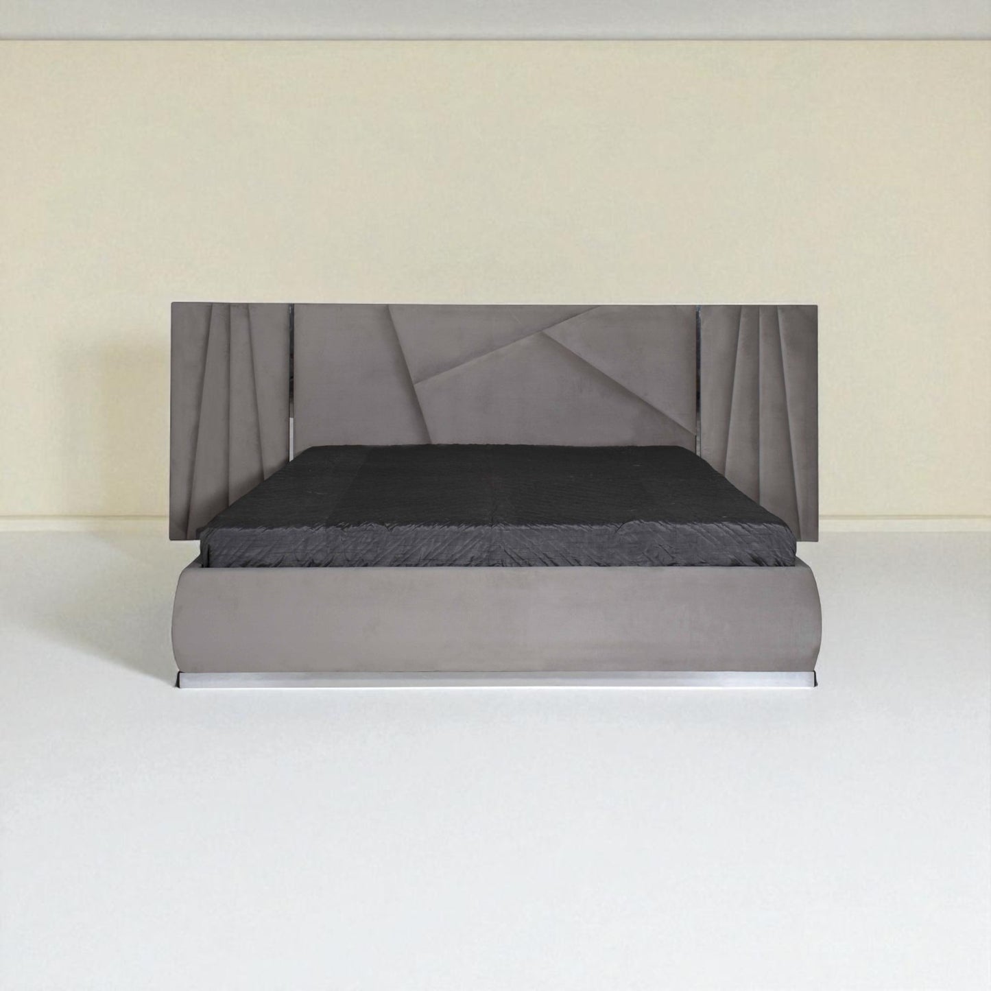 Grey upholstered bed with a geometric-pattern headboard and black bedding, shown from the front in a minimal room.