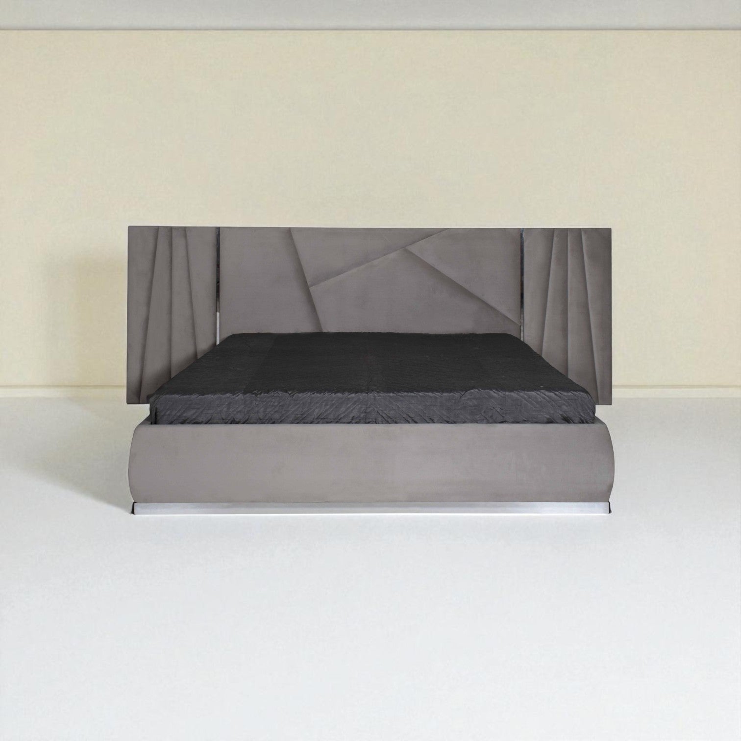 Grey upholstered bed with a geometric-pattern headboard and black bedding, shown from the front in a minimal room.
