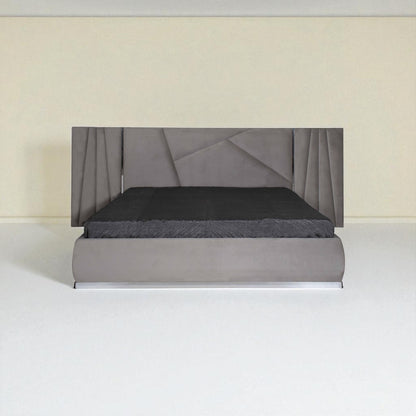 Grey upholstered bed with a geometric-pattern headboard and black bedding, shown from the front in a minimal room.