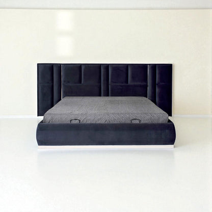Dark blue upholstered bed with a tall panel headboard and gray bedding in a minimalist white room.
