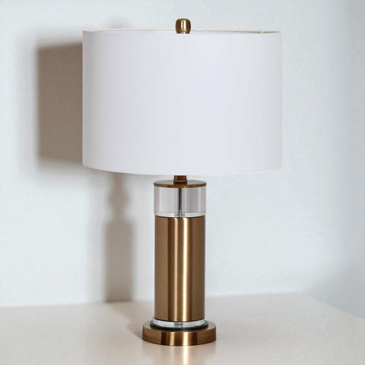 Table lamp with bronze base and white shade on a light surface.