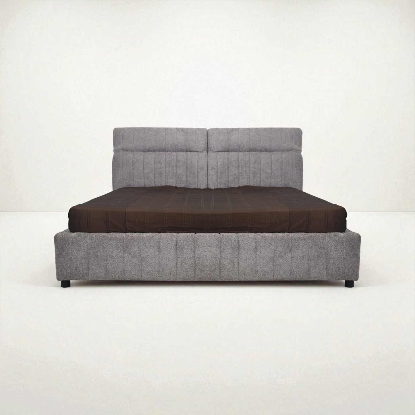Gray upholstered bed with a brown mattress on a white background