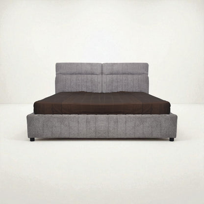 Gray upholstered bed with a brown mattress on a white background