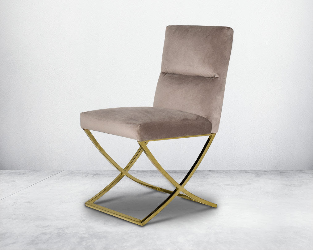 Dining chair upholstered in fabric with gold plated stainless steel legs in a cross design.