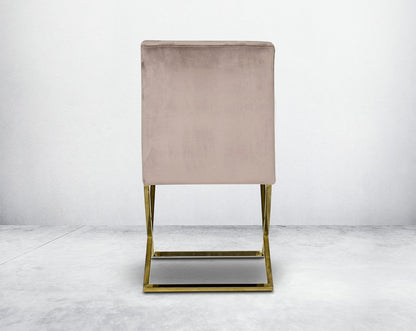 Dining chair with back  upholstered in fabric with gold plated stainless steel legs in a cross design.
